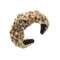 Dettaglio di un cerchietto in tweed con perle, strass e ciondoli da football su tessuto marrone - Marrone
