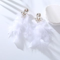 Detail of white feather earrings with shimmering rhinestones and soft fluffy textures - White