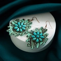 Detail of bohemian leaf print leather earrings with turquoise flower and bronze hooks - Green
