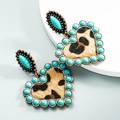 Detail van vintage hartvormige oorbellen met turquoise kralen en panterprint - Blauw
