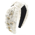 Dettaglio di un cerchietto bianco annodato con perle e strass a forma di cuore chic - Bianco