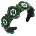 Detailed close-up of emerald green beads and crystal rhinestones on a vintage headband - Green