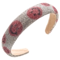 Dettaglio macro del cerchietto imbottito barocco con strass e motivi smiley rosa - Rosso