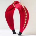 Detail eines roten geknoteten Stoffstirnbands mit Goldkette und weißen Perlenakzenten - Rot