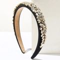 Detailed close-up of padded black velvet headband with sparkling marquise crystal embellishments - White