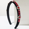 Detailed macro view of black velvet headband with red crystals and floral gemstone patterns - Red