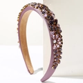 Detalle de diadema acolchada púrpura con brillantes de colores en engastes de metal dorado - Morado