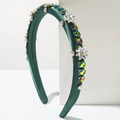 Close-up of luxury dark green satin headband with colorful rhinestones and crystals - Green