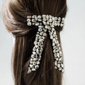 Elegante fiocco in velluto nero con strass di lusso indossato su capelli castani - Nero