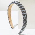 Dettaglio del cerchietto ondulato con strass scintillanti e perle bianche eleganti - Grigio