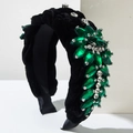 Detail of velvet braided headband featuring emerald crystals and luxury beadwork on white cubes - Green