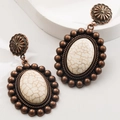 Dettaglio ravvicinato di orecchini boho in bronzo con pietre di turchese bianco screpolato - Bianco