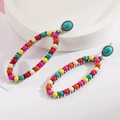 Detailed macro view of retro bohemian earrings with turquoise stones and colorful beadwork - Colorful