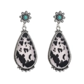 Detail view of silver floral stud with turquoise stone and cow print leather drop pendant - Black and White