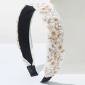 Detail der böhmischen Blumenstickerei mit goldbraunem Garn auf einem weißen Stirnband - Weiß