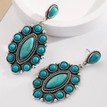 Detailed close-up of bohemian turquoise drop earrings with vintage silver metal alloy base - Turquoise