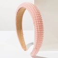 Close-up of pink pearl padded headband with soft velvet lining on white background - Champagne