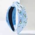 Close-up of light blue knotted headband with pearls, rhinestones and ocean charms - Blue