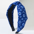 Detail of blue top knot headband featuring white and light blue evil eye pattern prints - Royal Blue