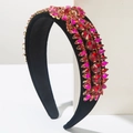 Detailed view of luxury baroque headband with red crystals on black velvet base - Rose Gold