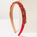Close-up of vintage red rhinestones and gold alloy hardware on a satin headband - Red