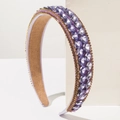 Close-up of a wide purple headband with sparkling oversized rhinestones and gold trim - Purple