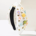 Dettaglio di fascia bianca testurizzata con fiori 3D colorati e strass scintillanti - Bianco