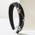 Close-up of black satin padded headband with intricate rhinestone floral patterns - Black