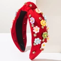 Détail d'un serre-tête rouge avec des fleurs 3D colorées et des strass étincelants - Rouge