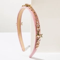 Close-up of pink velvet headband with rhinestones and gold bee insect charm detail - Pink