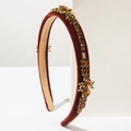 Close-up of red velvet headband with amber rhinestones and ornate insect details - Brown