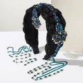 Detalle de una diadema vintage de satén negro con diamantes de imitación y borlas metálicas - Azul
