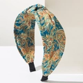 Detailed macro view of bohemian wide paisley print headband with twisted knot design - Green Gradient
