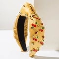 Detail van gele satijnen hoofdband met rode kersenbedeltjes en sprankelende strassteentjes - Geel