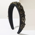 Detailed macro view of baroque padded headband with black rhinestones and gold claw settings - Black
