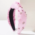 Dettaglio del cerchietto annodato rosa con perle sintetiche, strass e fiocco viola - Rosa