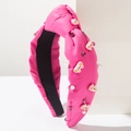 Dettaglio del cerchietto rosa con nodo, orsetto di resina, strass e perle bianche - Rosso rosa