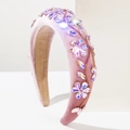 Détail des motifs floraux en cristal scintillant sur le serre-tête en velours violet - Rose