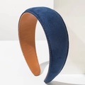 Navy blue padded velvet headband with caramel lining leaning on white block - Blue