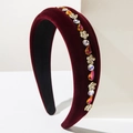 Macro detail of wine red velvet headband with colorful rhinestones and floral crystal gems - Red