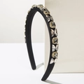 Detailed macro view of black satin headband with sparkling rhinestones and golden butterflies - Black