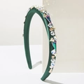Detail of dark green velvet headband with rhinestones and faux pearls on white stand - Green