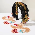 Close-up of ethnic style headband with golden metal floral charms and crystal tassels - Crystal Red