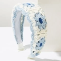 Detail of hand-crocheted floral headband with light blue and cream knit texture - Blue & White