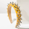 Macro shot of ginger yellow leather headband with silver conical rivets and soft beige lining - Yellow