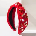 Detail eines roten Knotenstirnbands mit Strasssteinen, Perlen und goldenen XO-Buchstaben - Rot
