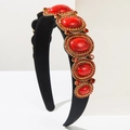 Detailed macro view of baroque headband with red gemstones and gold rhinestone settings - Red