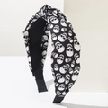 Close-up of knot headband with white skull pattern on black fabric for Halloween - Skull