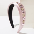 Détail d'un serre-tête en satin rose avec papillons en cristal et fleurs dorées - Rose