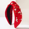 Macro detail of red knotted baseball headband with rhinestones and themed emblems - Red